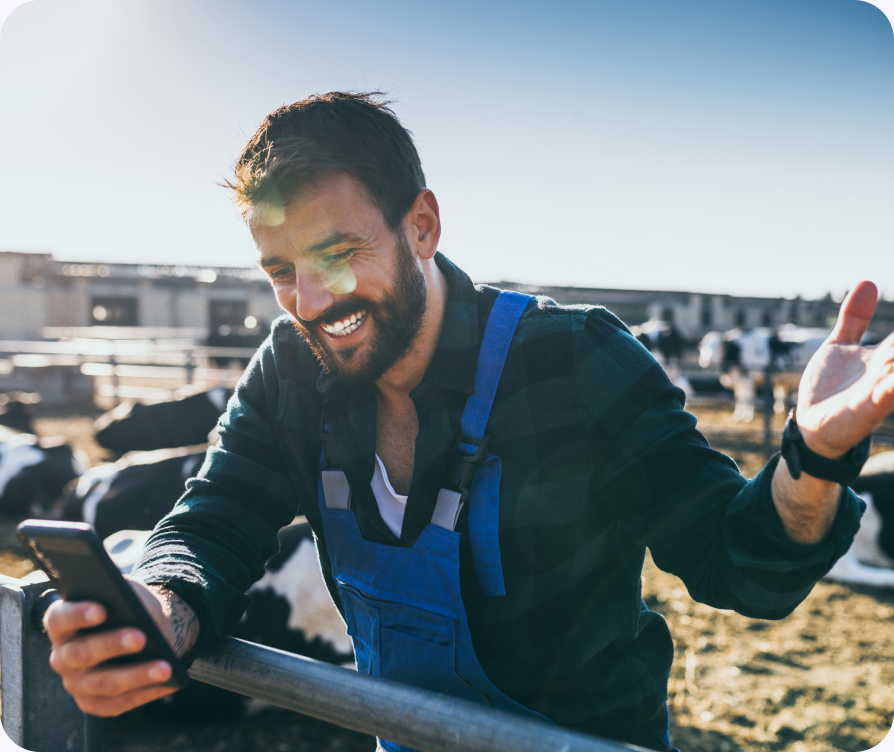 Agriculteur souriant utilisant son téléphone